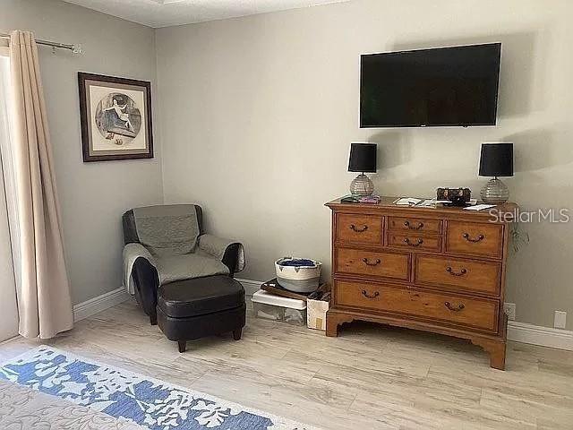 living area with light wood-style flooring and baseboards