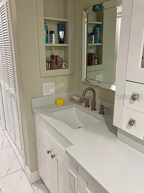 bathroom featuring marble finish floor and vanity