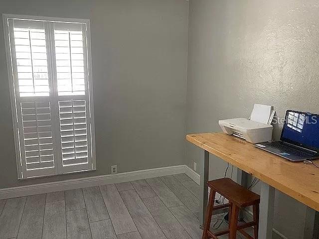 office area featuring baseboards and wood finished floors