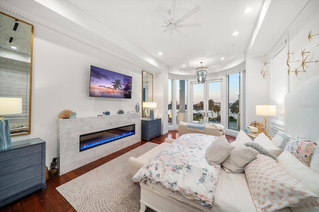 bedroom with wood finished floors, a glass covered fireplace, and recessed lighting