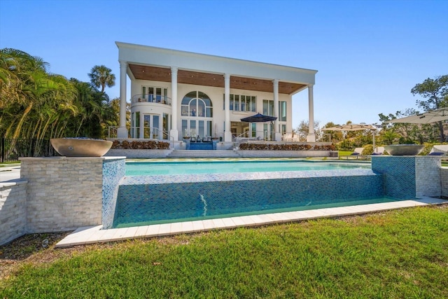 view of swimming pool with an infinity pool and a patio