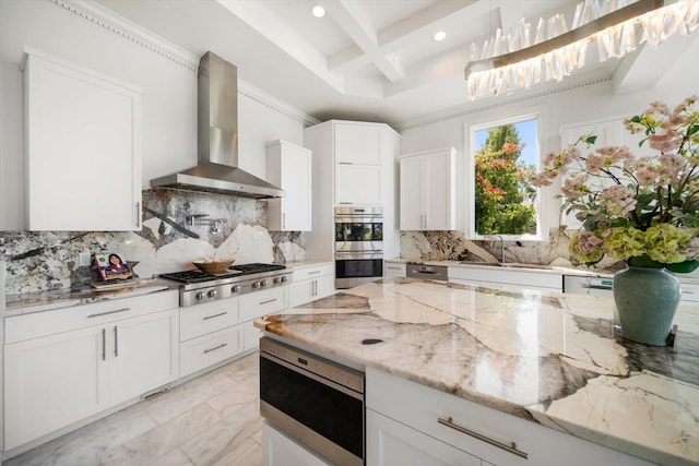 kitchen with coffered ceiling, appliances with stainless steel finishes, marble finish floor, wall chimney range hood, and a sink