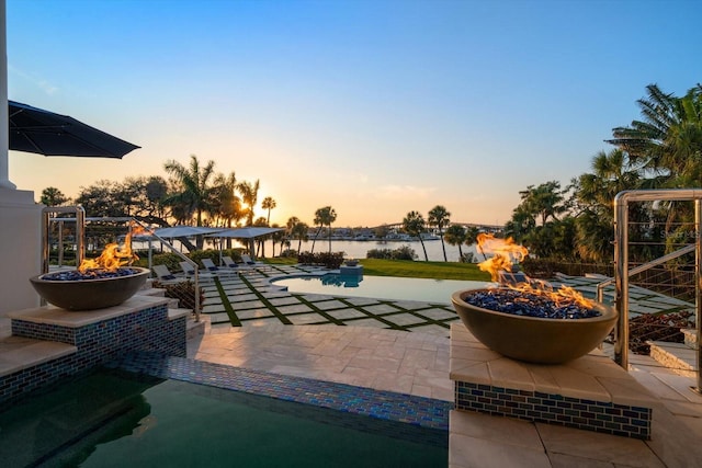 view of patio with an outdoor fire pit and a water view