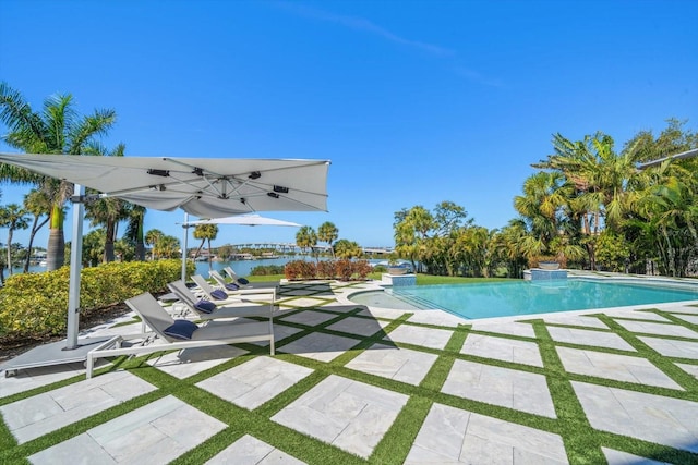 pool featuring a patio area and a water view