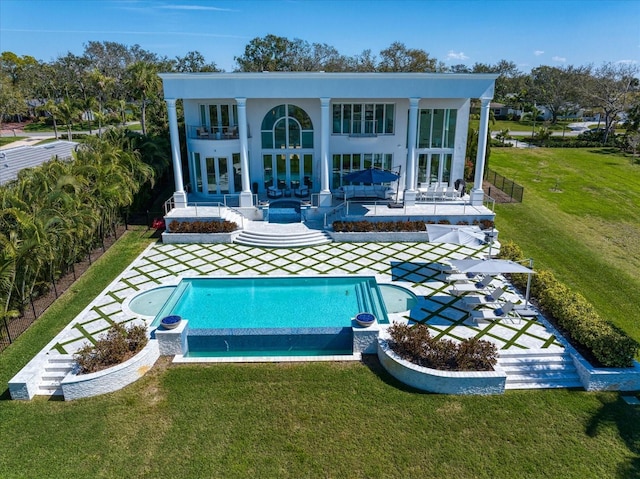 back of house featuring a patio, a lawn, fence, a balcony, and an outdoor pool