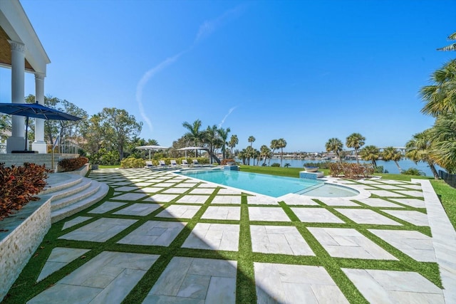 pool featuring a patio area and a water view