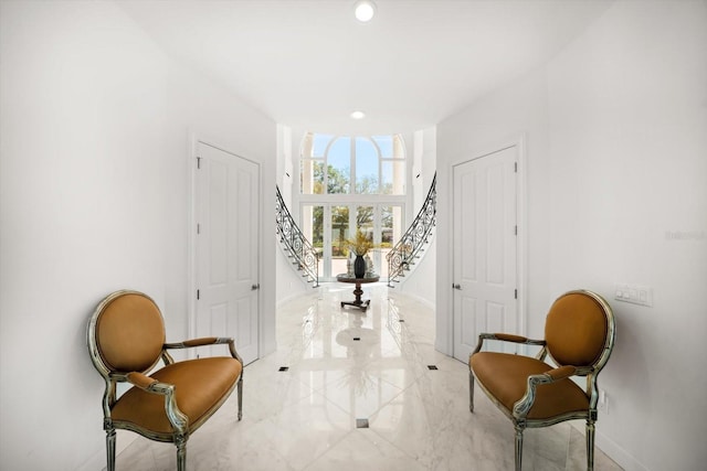 sitting room with marble finish floor, stairs, baseboards, and recessed lighting