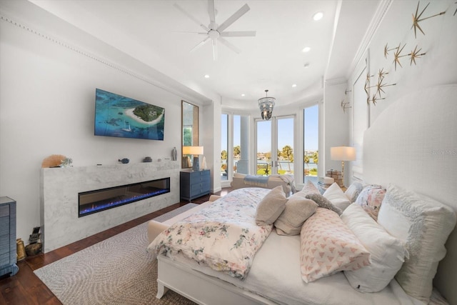 bedroom with a glass covered fireplace, access to outside, recessed lighting, and wood finished floors