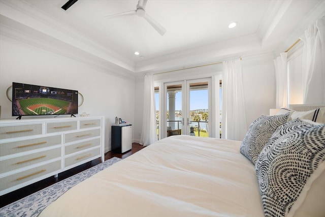 bedroom with access to exterior, french doors, crown molding, a raised ceiling, and wood finished floors