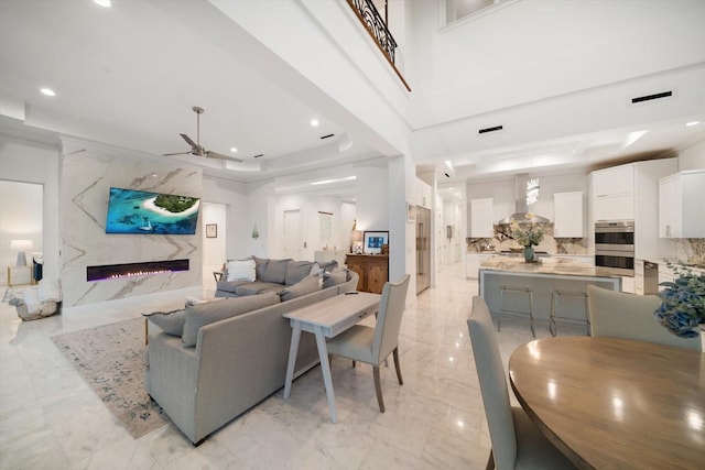 living area with marble finish floor, recessed lighting, visible vents, a ceiling fan, and a high end fireplace