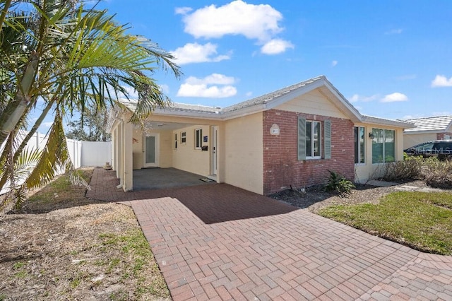 rear view of house with brick siding and fence