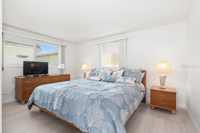 bedroom with light wood-style flooring and baseboards