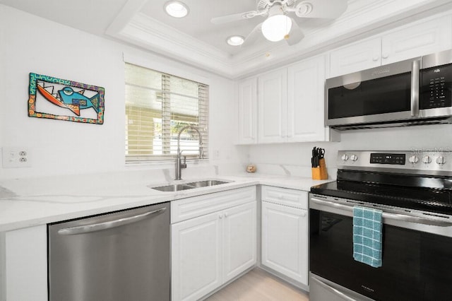 kitchen featuring a sink, crown molding, white cabinets, and stainless steel appliances