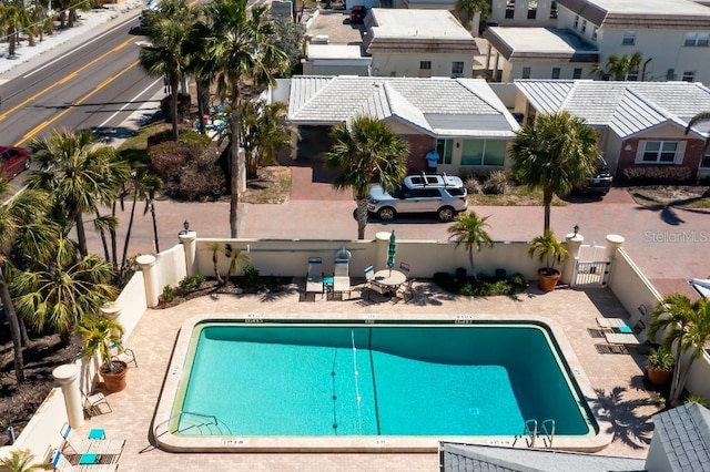 pool with a patio, a fenced backyard, and a gate