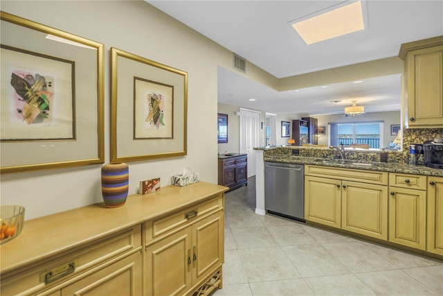 kitchen featuring light tile patterned floors, visible vents, a sink, dishwasher, and a peninsula