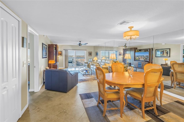 dining space featuring ceiling fan, light tile patterned flooring, visible vents, and baseboards