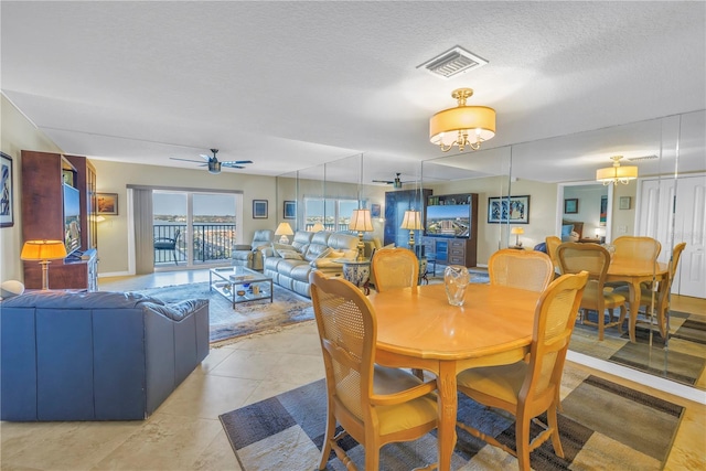 dining room with light tile patterned floors, ceiling fan, visible vents, and a textured ceiling