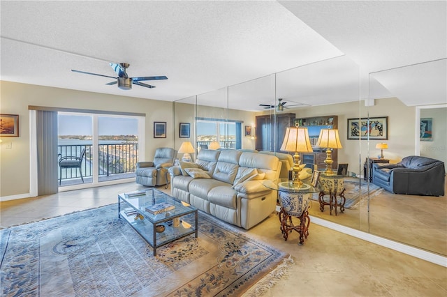 living area featuring tile patterned flooring, plenty of natural light, ceiling fan, and a textured ceiling