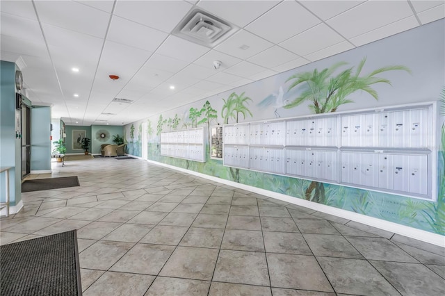 interior space with visible vents, mail area, tile patterned flooring, a drop ceiling, and baseboards