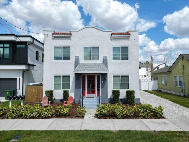 view of front of home with driveway, a gate, fence, and stucco siding