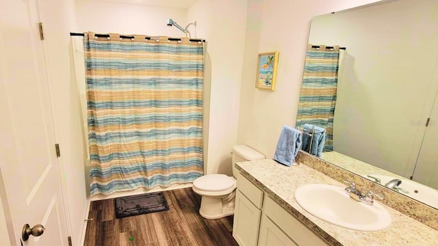 full bathroom featuring curtained shower, vanity, toilet, and wood finished floors