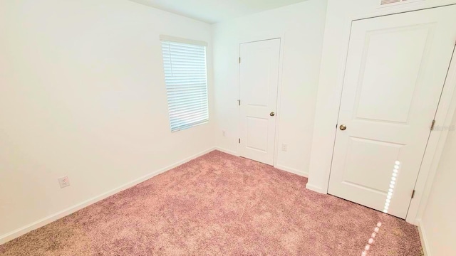 unfurnished bedroom with light carpet and baseboards