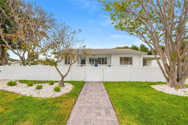 view of front of house with a fenced front yard, a front yard, and a gate