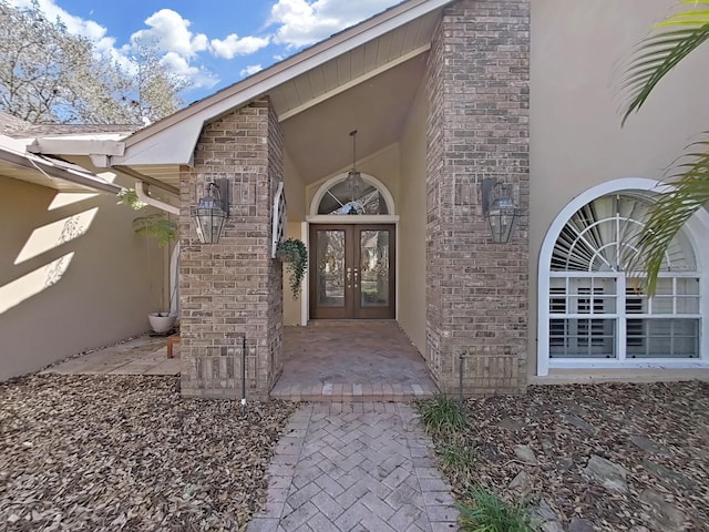 doorway to property featuring french doors and brick siding