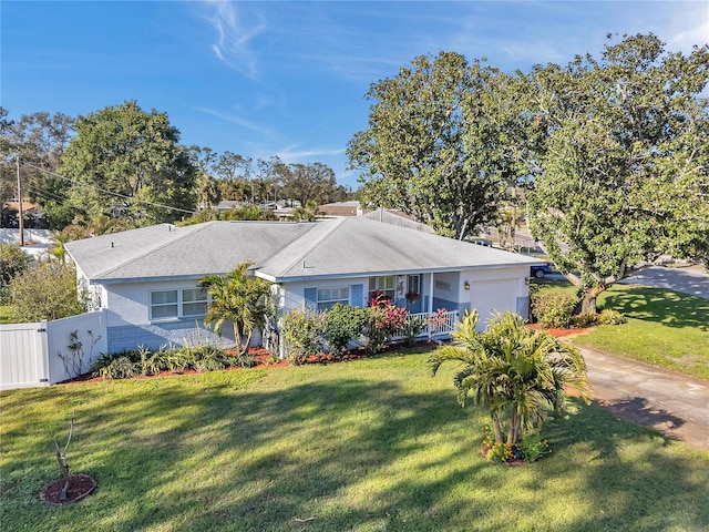 ranch-style house featuring an attached garage, a gate, fence, and a front lawn