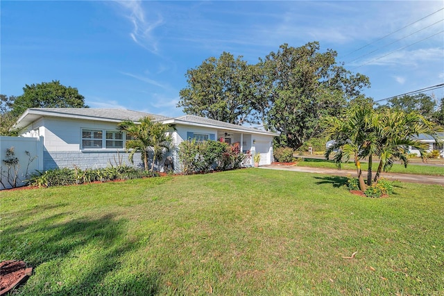 ranch-style house with driveway, an attached garage, fence, and a front yard