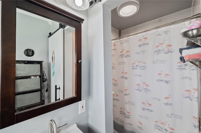 bathroom featuring a shower with curtain and a sink