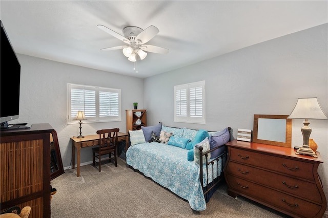 bedroom featuring a textured wall, ceiling fan, and light colored carpet