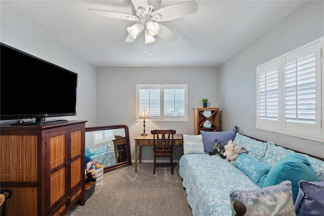 carpeted living area featuring ceiling fan and baseboards