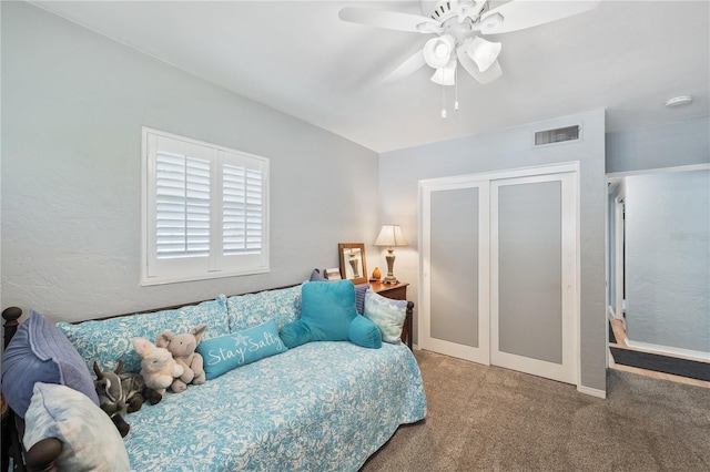 carpeted bedroom featuring a closet, visible vents, and a ceiling fan