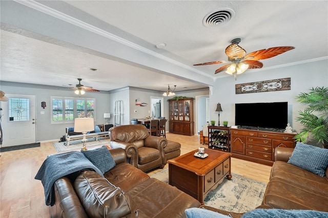 living room with a ceiling fan, light wood-type flooring, visible vents, and crown molding