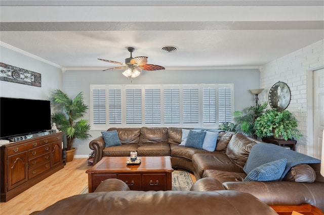 living area with ornamental molding, visible vents, light wood finished floors, and a ceiling fan