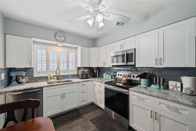 kitchen featuring white cabinets, backsplash, stainless steel appliances, and a sink