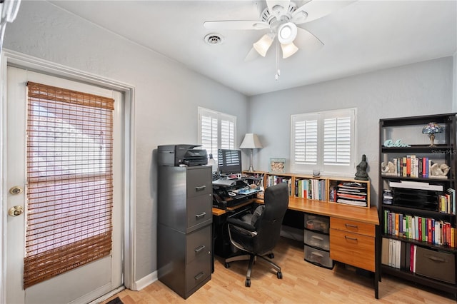 office space featuring a ceiling fan, light wood-type flooring, and visible vents