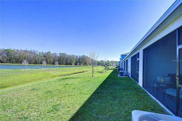 view of yard with central AC unit and a water view