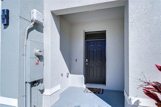 view of exterior entry with stucco siding