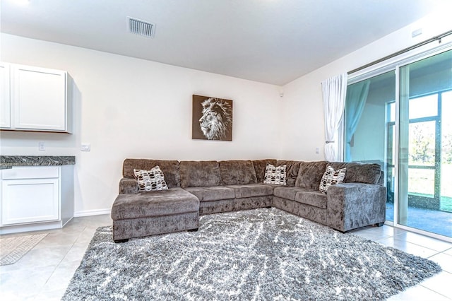 living room with light tile patterned floors, baseboards, and visible vents