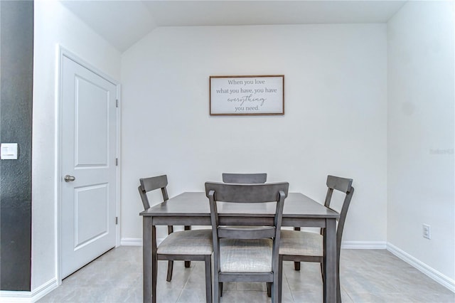 dining space with lofted ceiling and baseboards