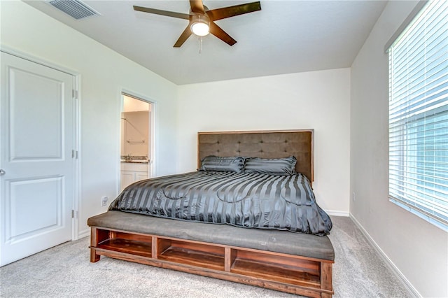 bedroom featuring visible vents, ensuite bathroom, a ceiling fan, carpet flooring, and baseboards