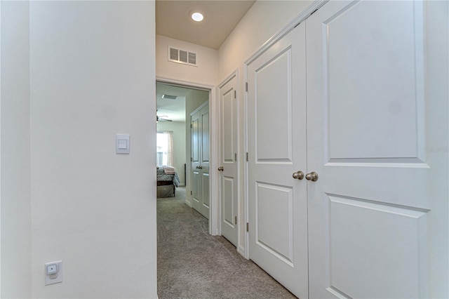 hallway featuring visible vents and light carpet