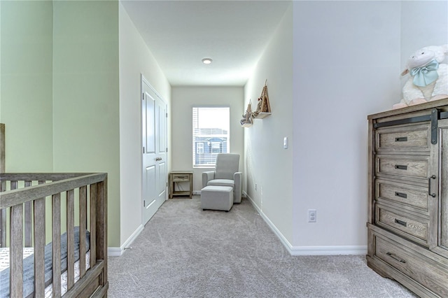 carpeted bedroom with a nursery area and baseboards