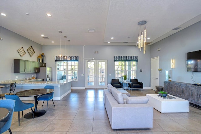 living room with visible vents, light tile patterned floors, recessed lighting, french doors, and a high ceiling