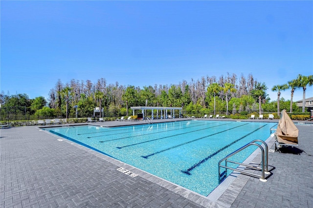 community pool featuring a patio area, a pergola, and fence