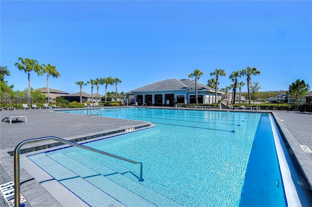 community pool with a patio and fence