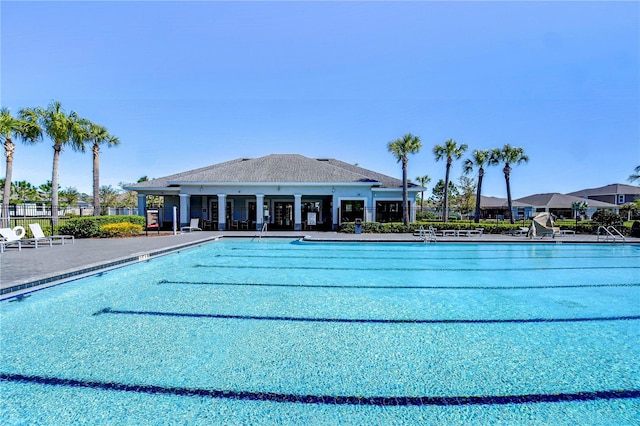 community pool with a patio area and fence