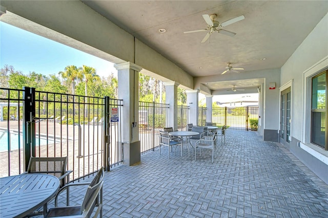 view of patio featuring outdoor dining area, fence, and ceiling fan